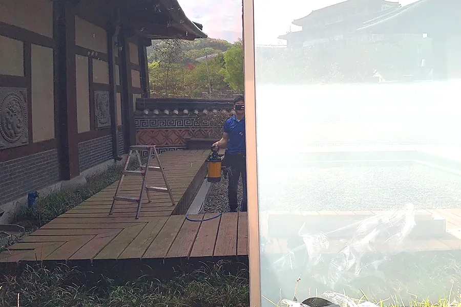 박물관 유리창 비산방지필름 시공 과정, 미시공 구간과 시공면이 대비되는 클로즈업