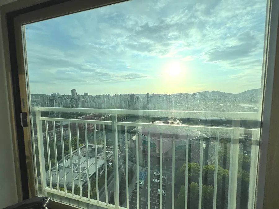 고층 아파트 발코니 통유리창 열차단필름 시공 후 도시 전망 전경